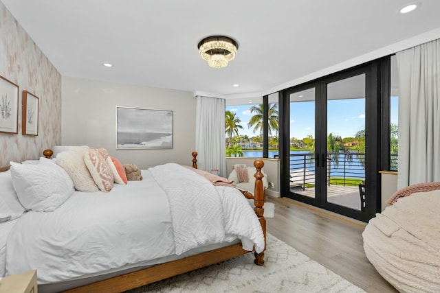 bedroom with a chandelier, recessed lighting, french doors, access to exterior, and wood finished floors