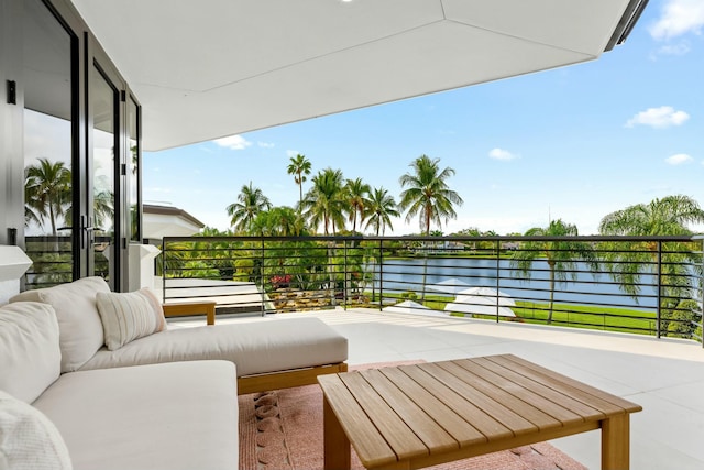 view of patio / terrace with an outdoor living space, a balcony, and a water view