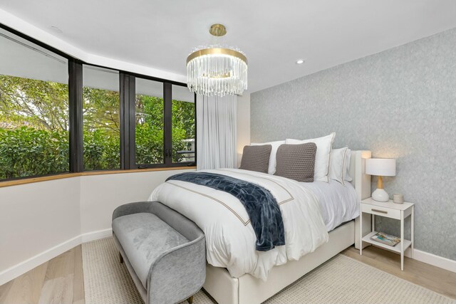 living area with wallpapered walls, baseboards, a wealth of natural light, and wood finished floors