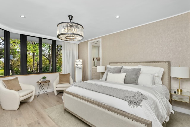 bedroom with baseboards, recessed lighting, wood finished floors, and a notable chandelier