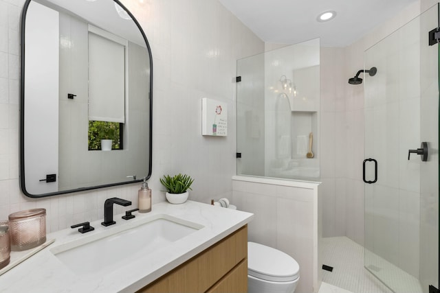 full bath with tile walls, recessed lighting, toilet, a shower stall, and vanity