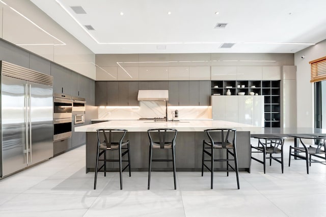 kitchen with stainless steel appliances, tasteful backsplash, visible vents, and modern cabinets