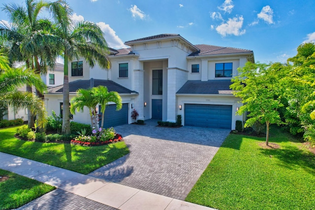 view of front of home with an attached garage, a front lawn, decorative driveway, and stucco siding