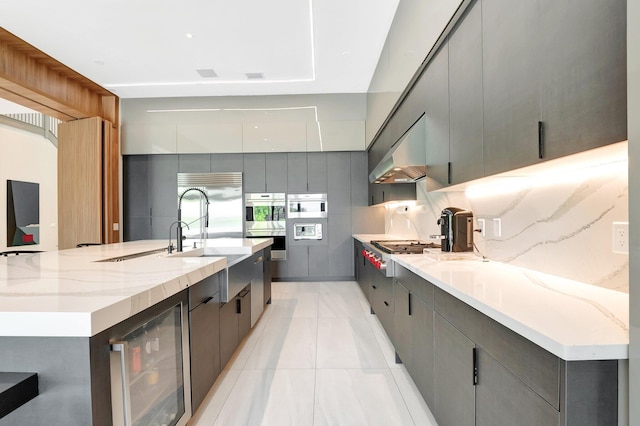 kitchen featuring tasteful backsplash, beverage cooler, modern cabinets, appliances with stainless steel finishes, and ventilation hood