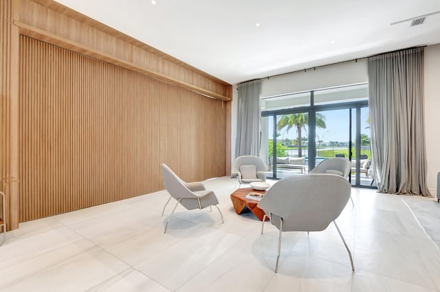 living area featuring wooden walls and visible vents