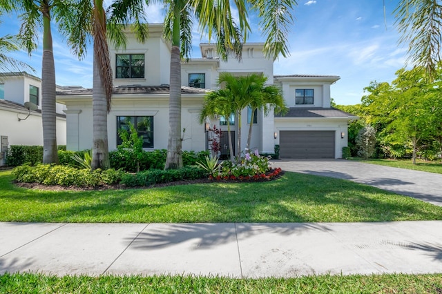 view of front of property featuring a garage, decorative driveway, a front lawn, and stucco siding