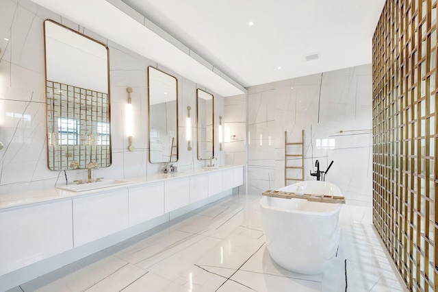 bathroom featuring a walk in shower, a freestanding tub, a sink, tile walls, and double vanity