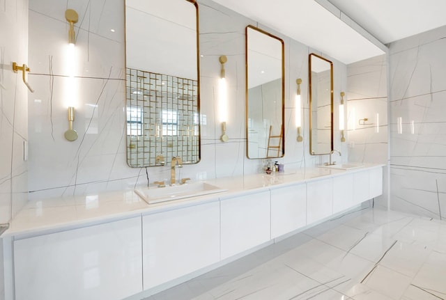 full bathroom with double vanity, tile walls, and a sink