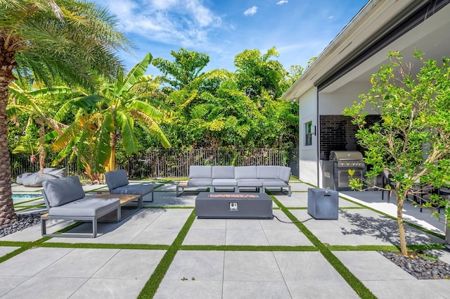 view of patio / terrace featuring a grill, fence, an outdoor kitchen, and an outdoor hangout area