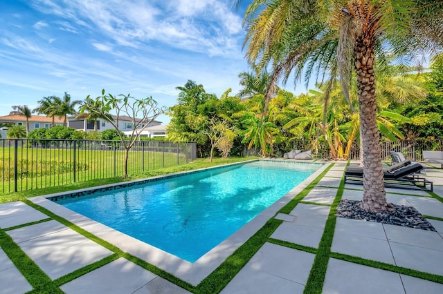 view of swimming pool featuring a patio area, a fenced backyard, a fenced in pool, and a lawn