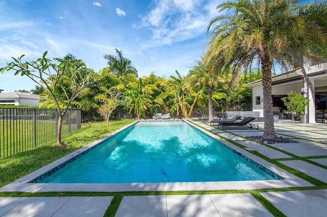 view of swimming pool featuring a lawn, a patio area, fence, and a fenced in pool