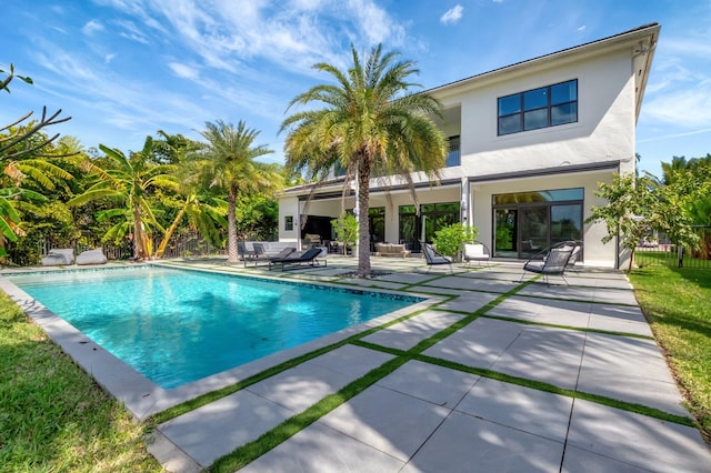 pool with a patio area and fence