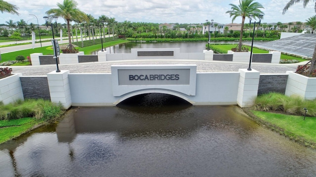 view of front of property featuring a water view and fence