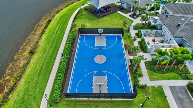 view of basketball court featuring community basketball court, a water view, and fence