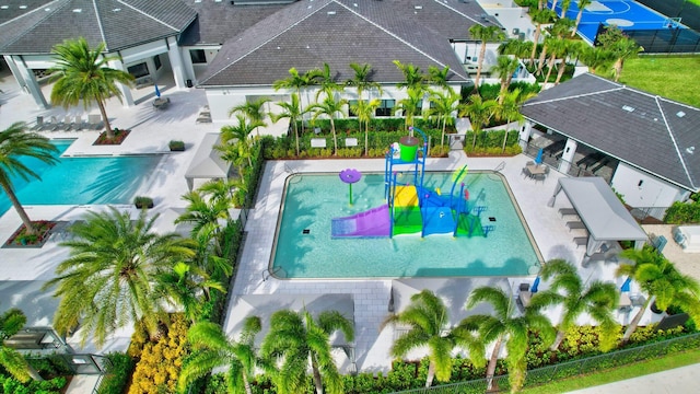 view of pool with a patio area, fence, and a water play area