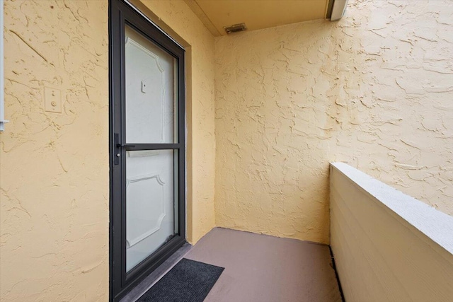 doorway to property with stucco siding and a balcony