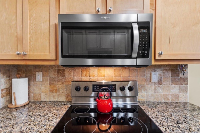 kitchen featuring stone countertops, light brown cabinetry, tasteful backsplash, and stainless steel appliances