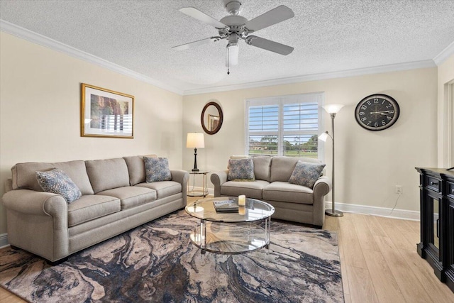 living room with ceiling fan, a textured ceiling, baseboards, light wood-style floors, and ornamental molding
