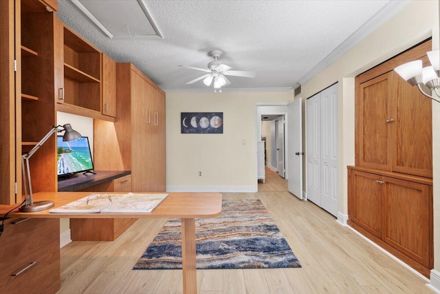 unfurnished office with light wood finished floors, ceiling fan, ornamental molding, and a textured ceiling