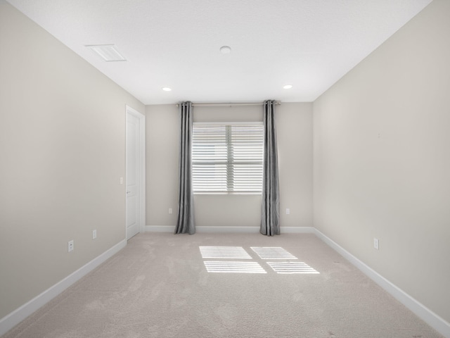 spare room featuring baseboards, light colored carpet, and recessed lighting