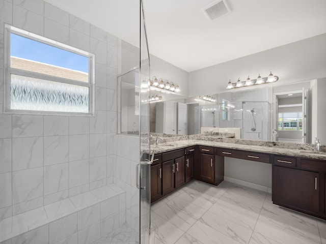 bathroom with marble finish floor, visible vents, a shower stall, and vanity