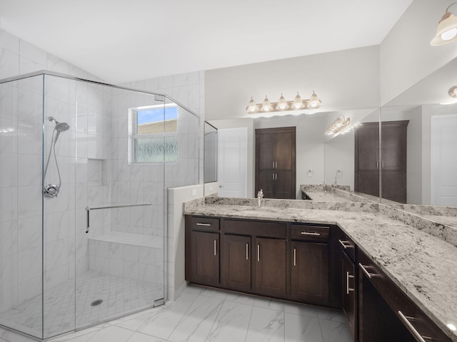 full bathroom with a stall shower, marble finish floor, vaulted ceiling, and vanity