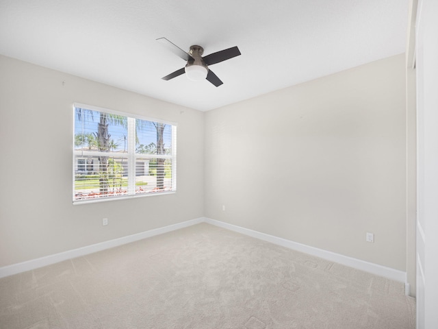 spare room featuring carpet floors, ceiling fan, and baseboards