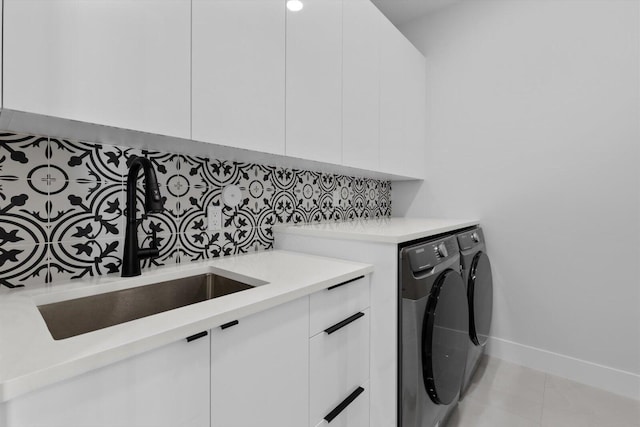 laundry area featuring sink, independent washer and dryer, and cabinets