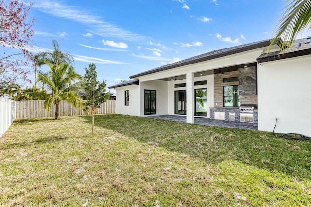 rear view of house featuring a patio, a yard, and ceiling fan