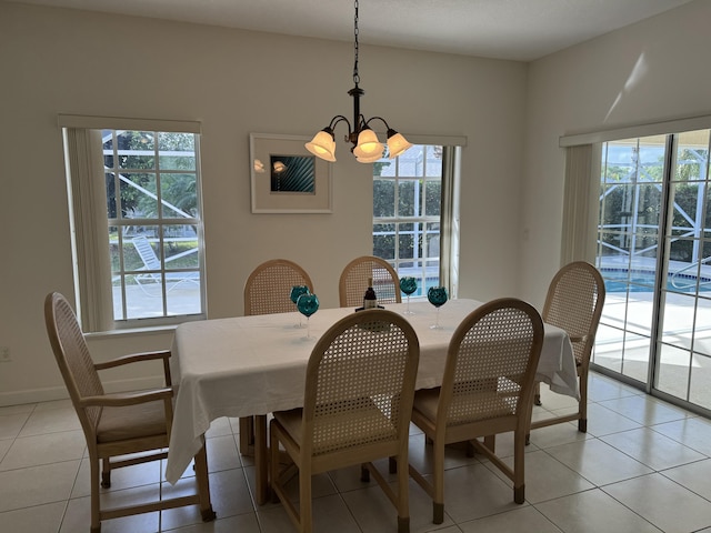 dining room with an inviting chandelier, light tile patterned floors, and baseboards