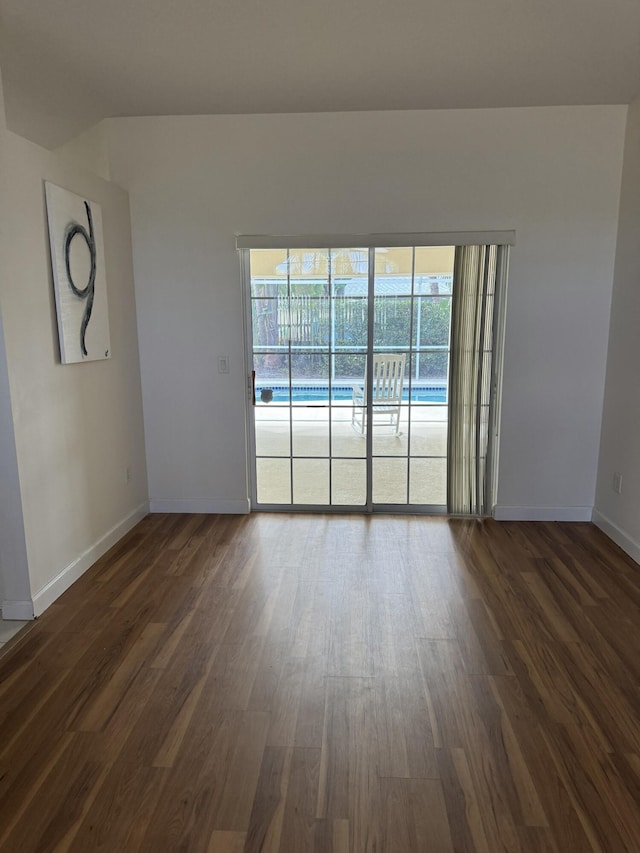 empty room featuring dark wood-style floors and baseboards