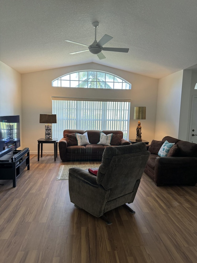 living room with a textured ceiling, wood finished floors, lofted ceiling, and a healthy amount of sunlight