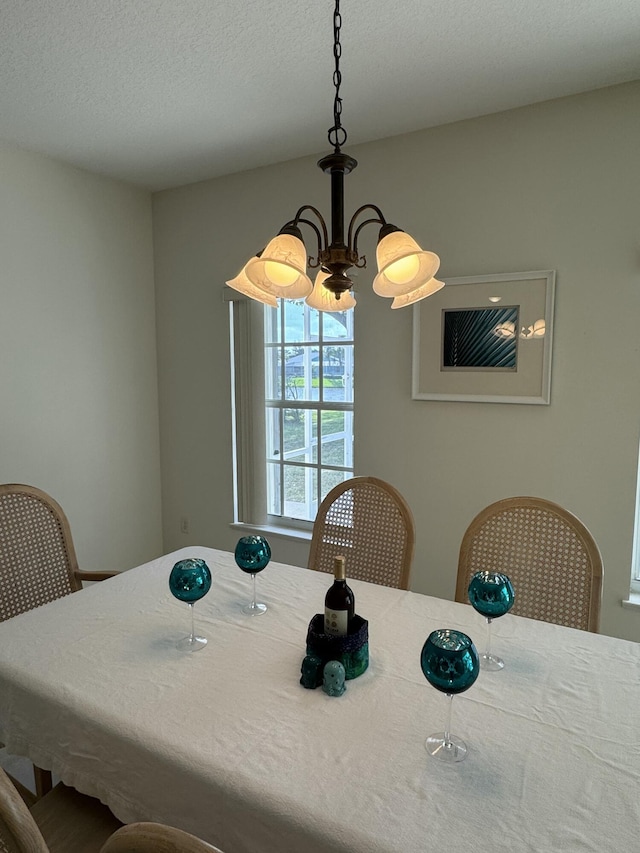 dining area with a textured ceiling and a chandelier