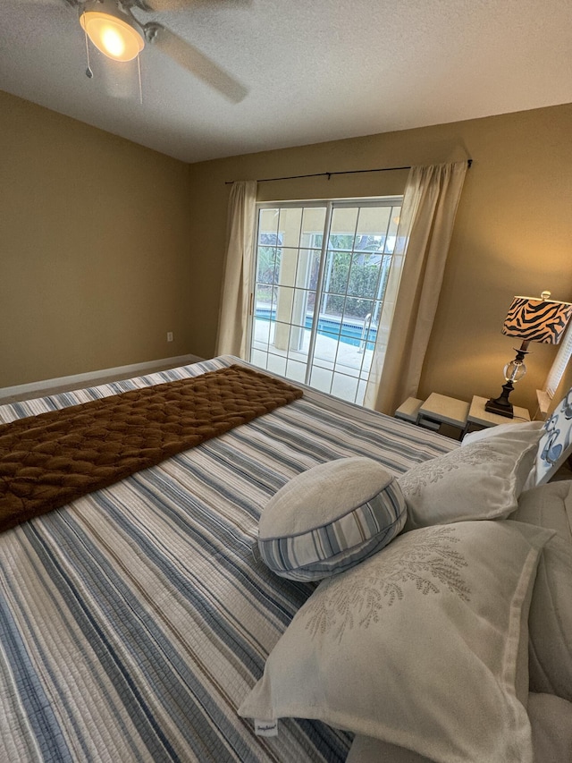 bedroom with access to exterior, a textured ceiling, and a ceiling fan