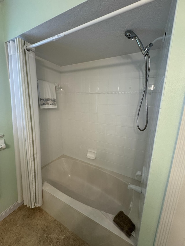 bathroom with a textured ceiling and shower / tub combo with curtain