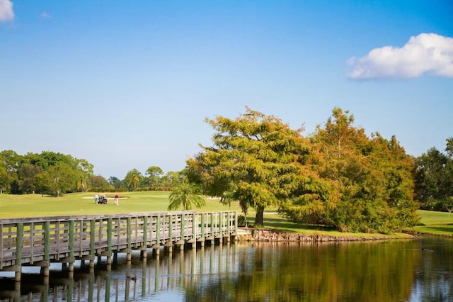 dock area featuring a water view and a lawn