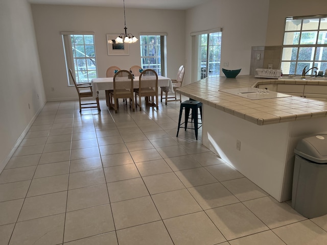 dining space with light tile patterned floors, baseboards, and a chandelier