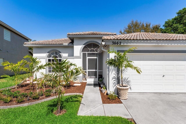 mediterranean / spanish home featuring a garage, driveway, a tile roof, and stucco siding