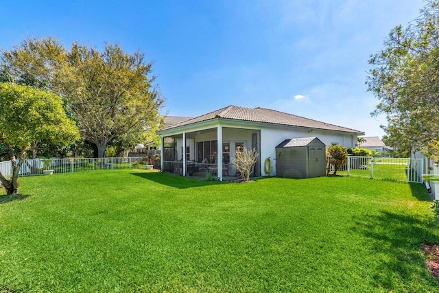 back of house with a fenced backyard, a storage unit, and a yard