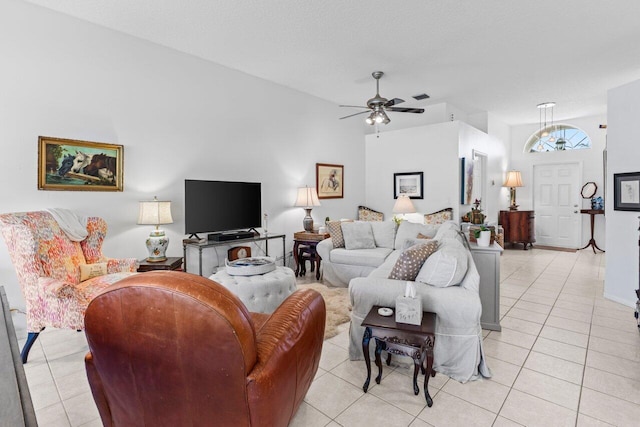 living room featuring ceiling fan, a textured ceiling, and light tile patterned floors