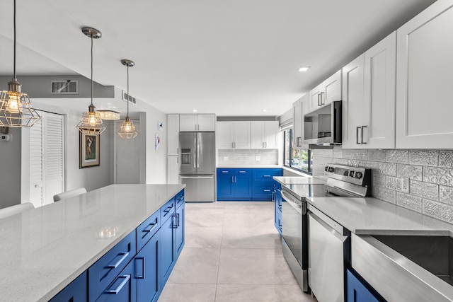 11205 Green Lake Dr Unit 201, Boynton Beach, FL 33437 - kitchen with appliances with stainless steel finishes, blue cabinets, decorative backsplash, white cabinets, and decorative light fixtures