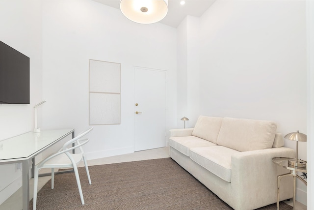 carpeted living area featuring baseboards