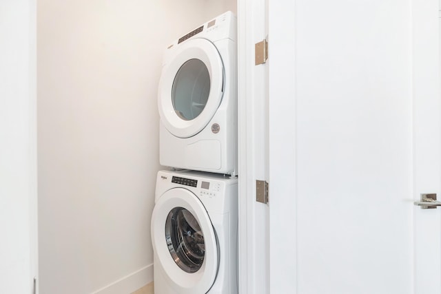 clothes washing area featuring stacked washer / drying machine and laundry area