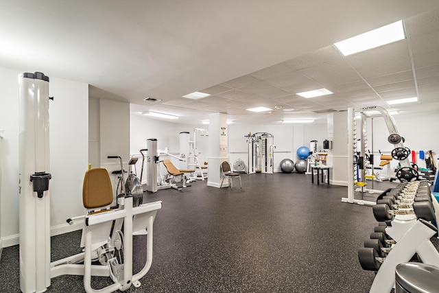 workout area with visible vents, baseboards, and a drop ceiling