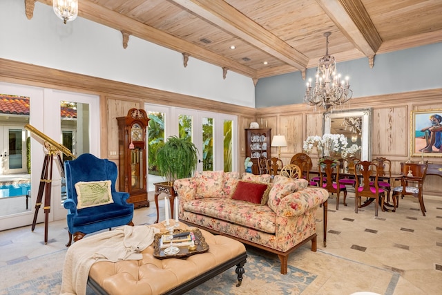 living area with a towering ceiling, wood ceiling, beamed ceiling, french doors, and a notable chandelier