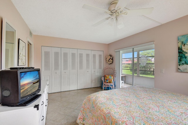 bedroom featuring a textured ceiling, a closet, ceiling fan, and light tile patterned floors