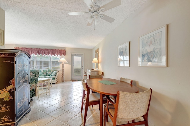 dining space with a textured ceiling, ceiling fan, and light tile patterned floors