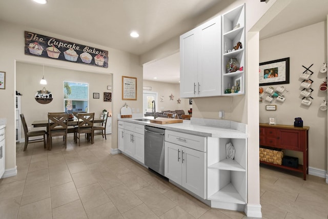 kitchen featuring white cabinetry, stainless steel dishwasher, sink, and decorative light fixtures