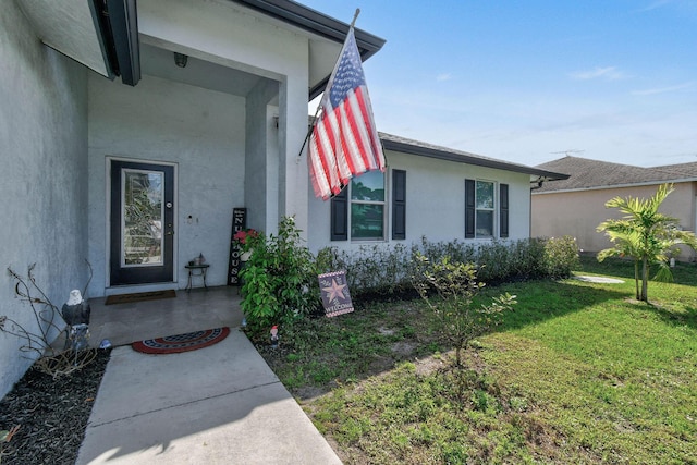 entrance to property with a lawn