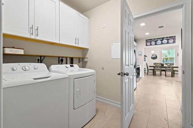 washroom with light tile patterned flooring, cabinets, and separate washer and dryer